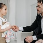 girl shaking hands with a man in a suit